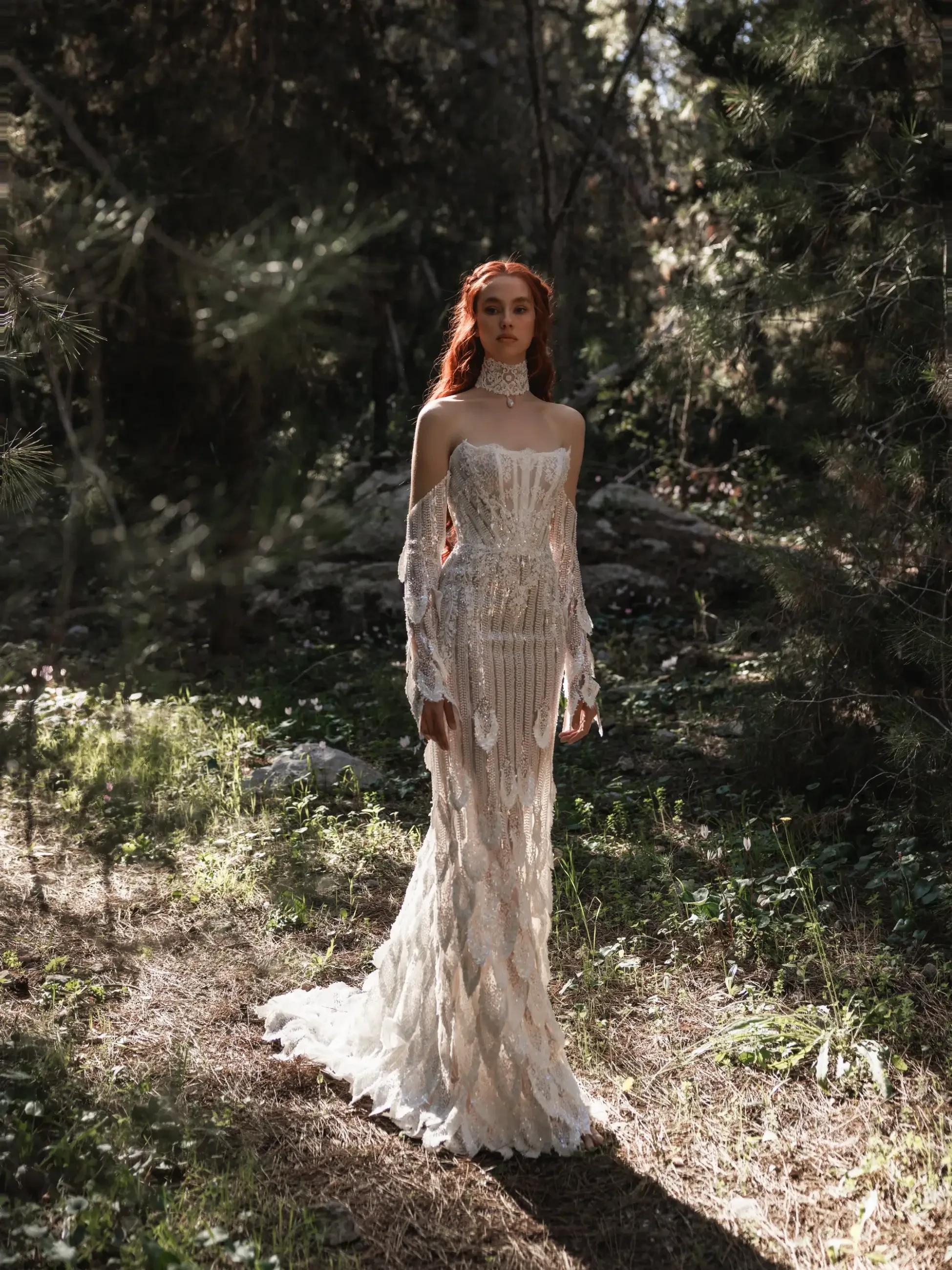 A woman stands in a sunlit forest wearing a delicate, off-shoulder, lace gown with intricate patterns. Her expression is serene, and the scene feels ethereal.