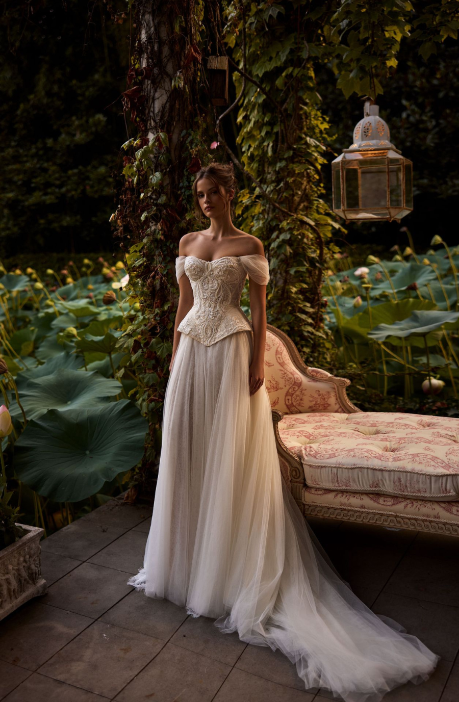 model is wearing an off the shoulder wedding dress by milla nova