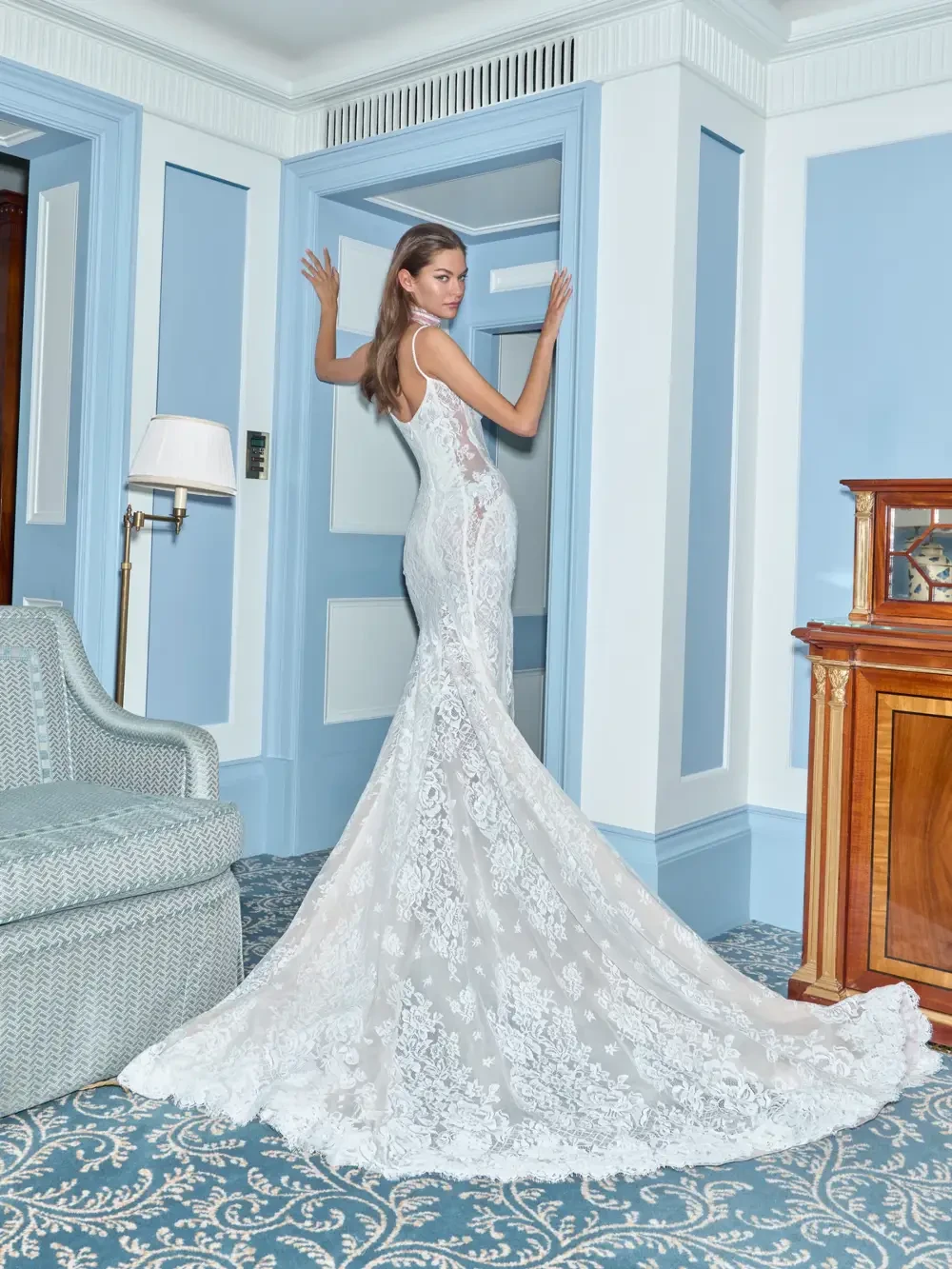model is wearing a sleeveless lace bridal gown