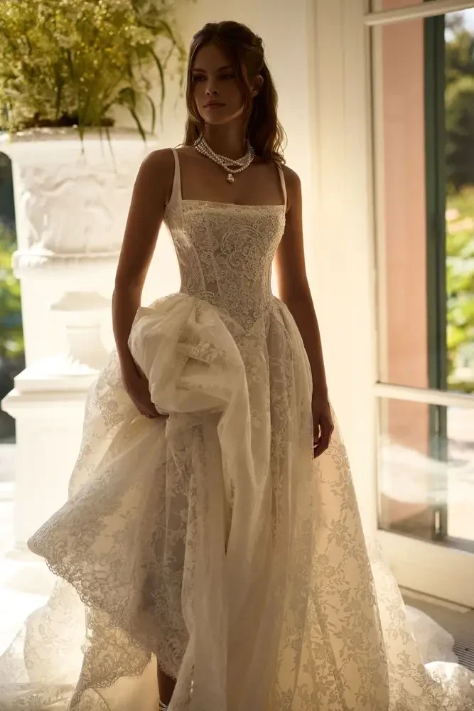 model is wearing a sleeveless lace a-line wedding gown